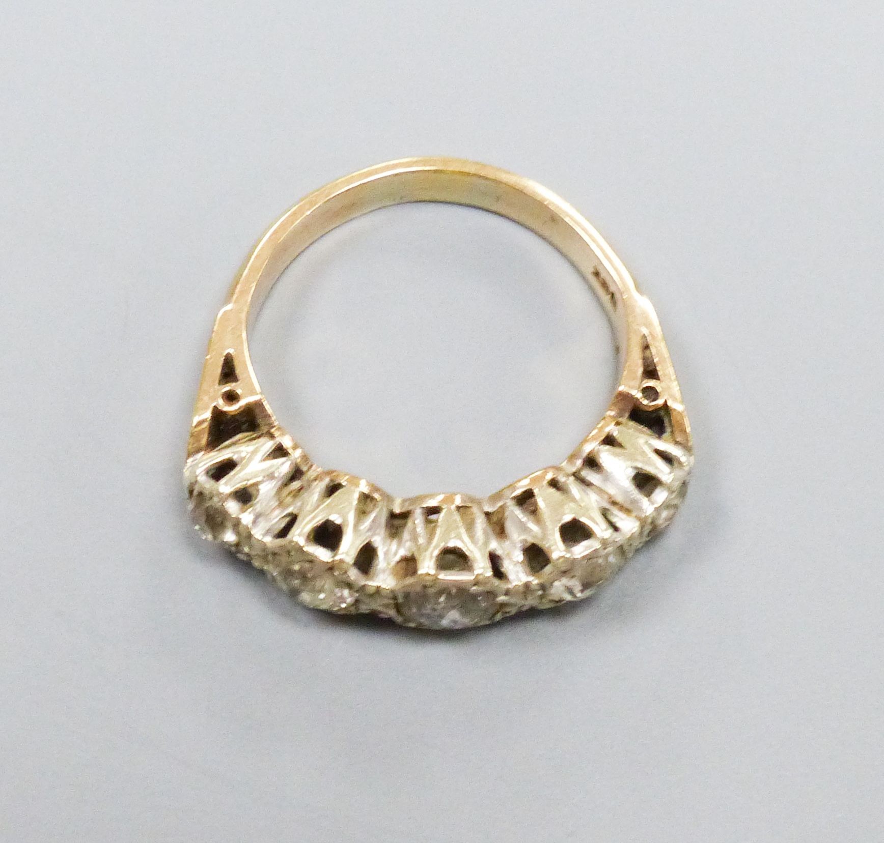 A five-stone diamond ring, 9ct white and yellow gold setting, claw-set with carved shoulders, size M, gross weight 4.3 grams.